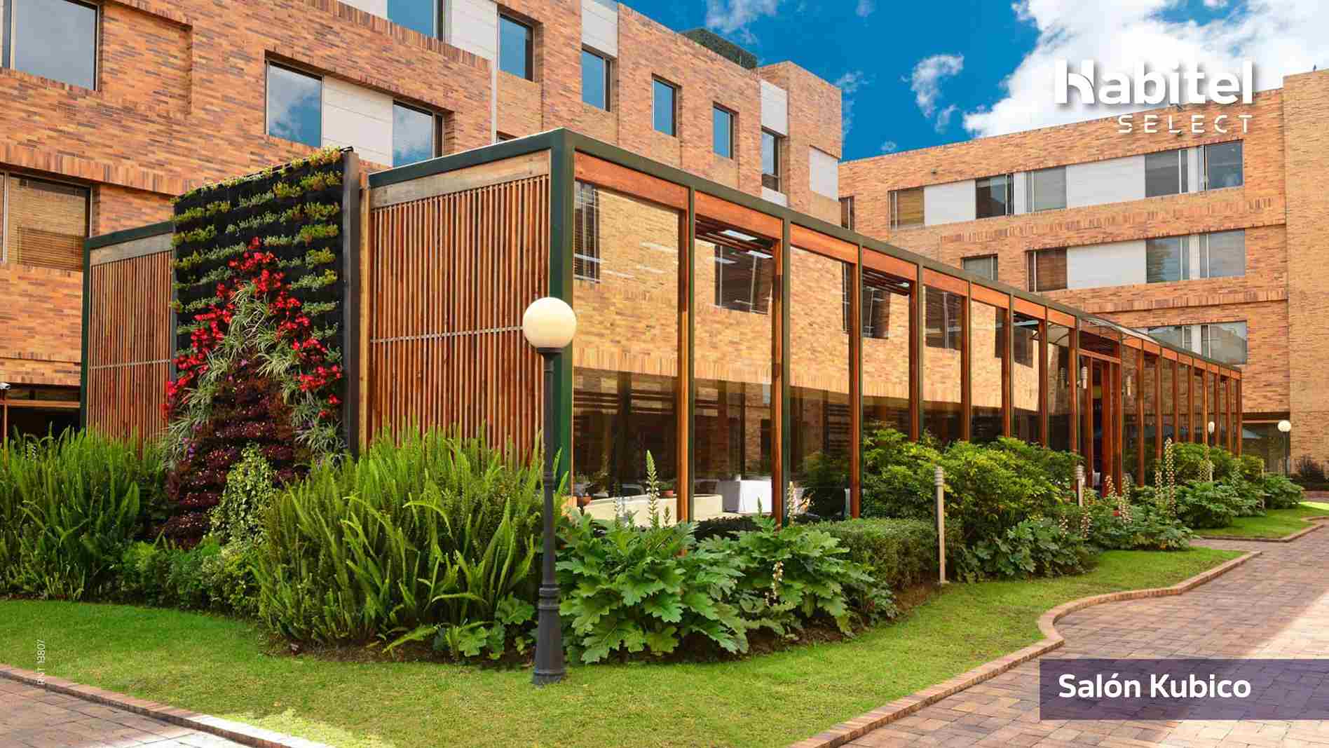  Fachada de edificio moderno en ladrillo. Hay varia vegetación alrerdedor de la estructura.