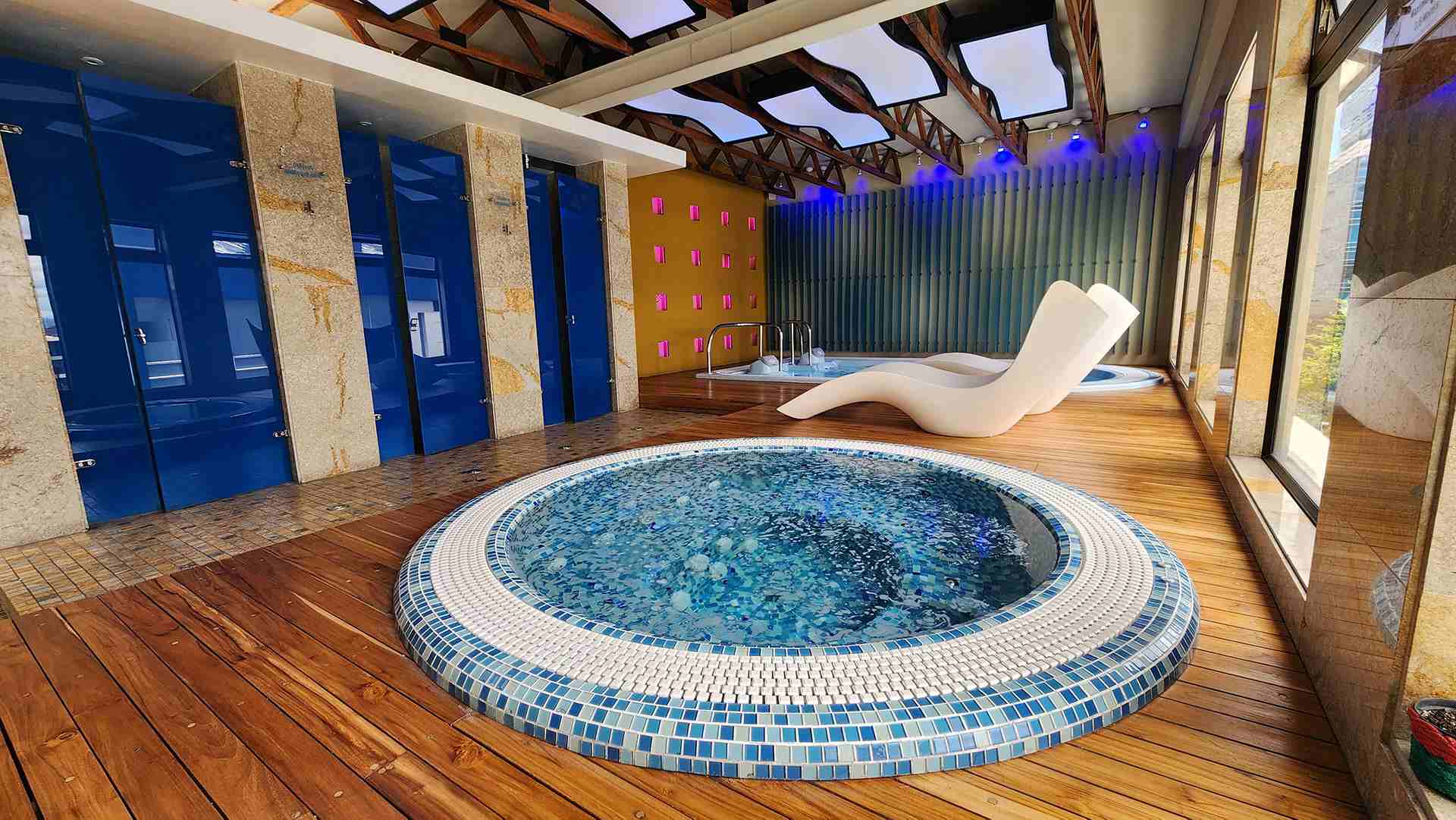 Salón en el que hay un jacuzzi y una silla para descansar.