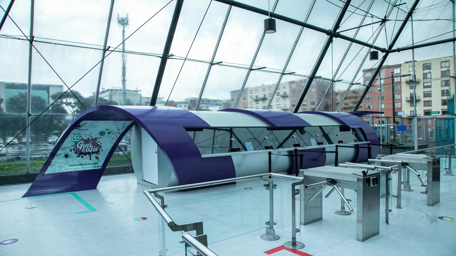 Interior space fully surrounded by glass walls. A circular structure stands out, resembling a giant tube designed for public interaction or attention.