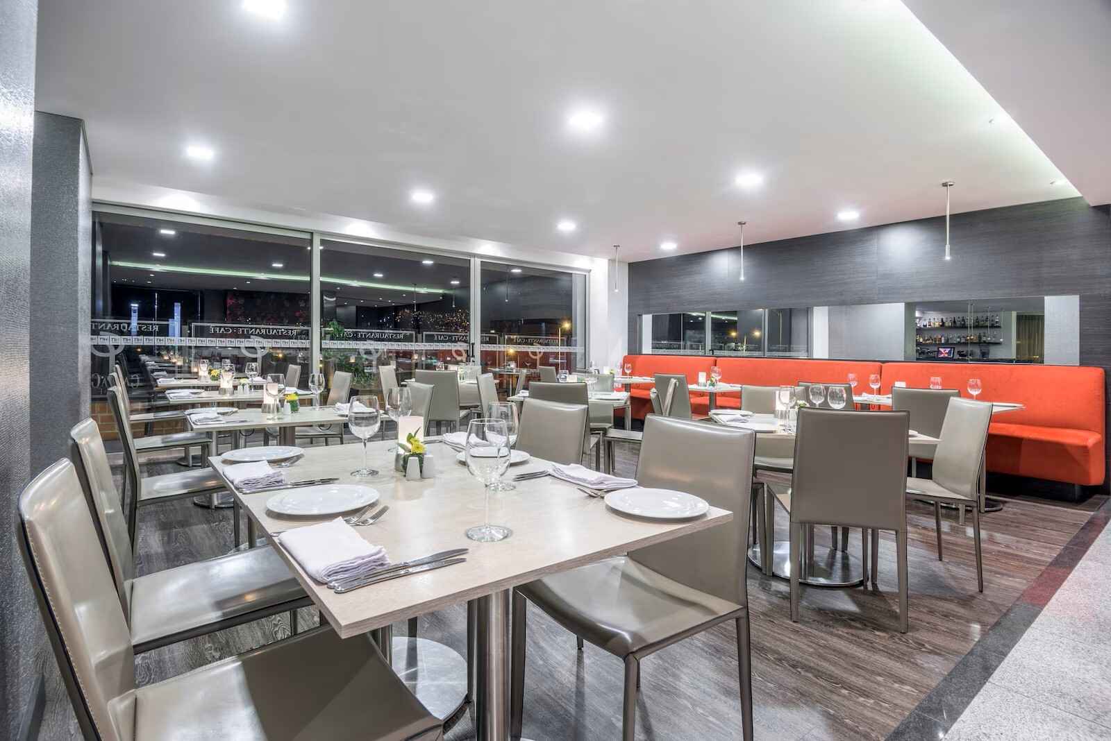 Interior de un salón con mesas y sillas dispuestas como en un comedor.