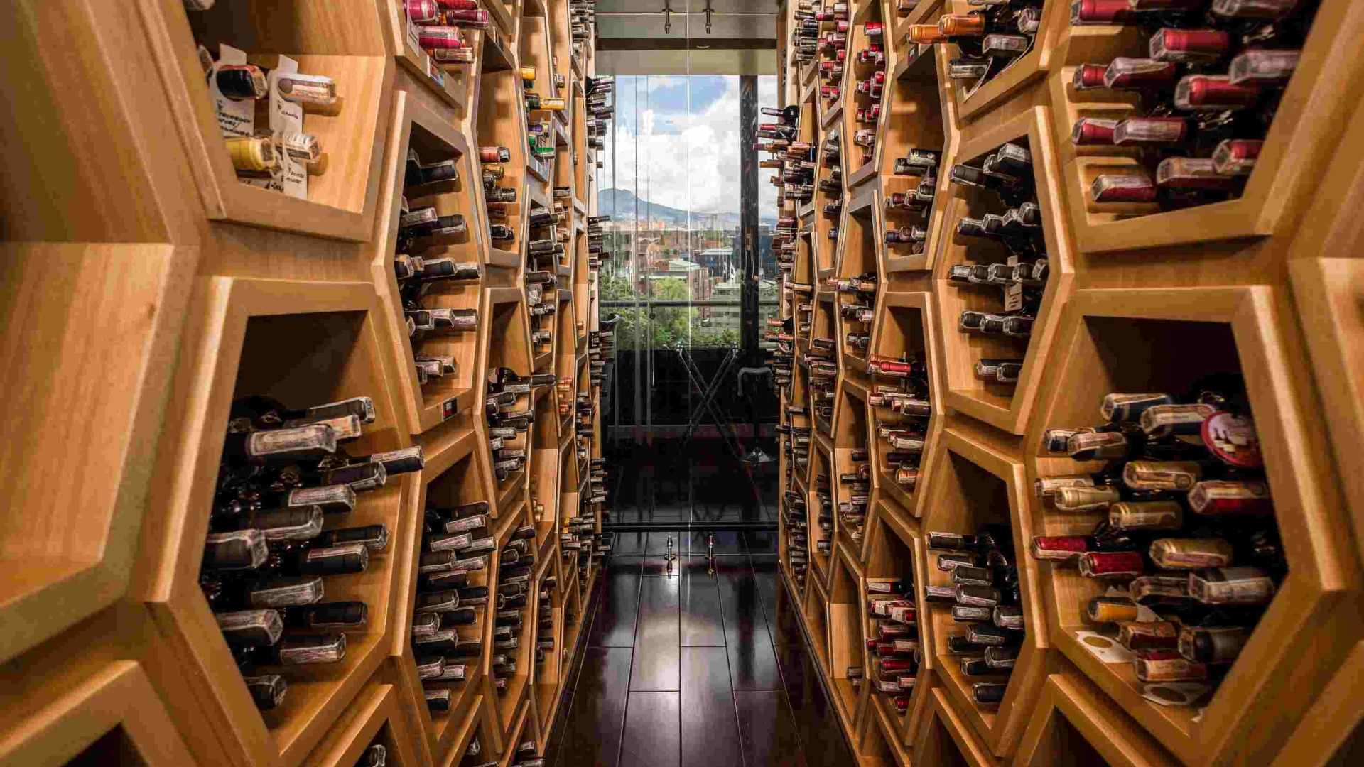  Interior of a modern wine cellar, divided in two and filled with bottles.