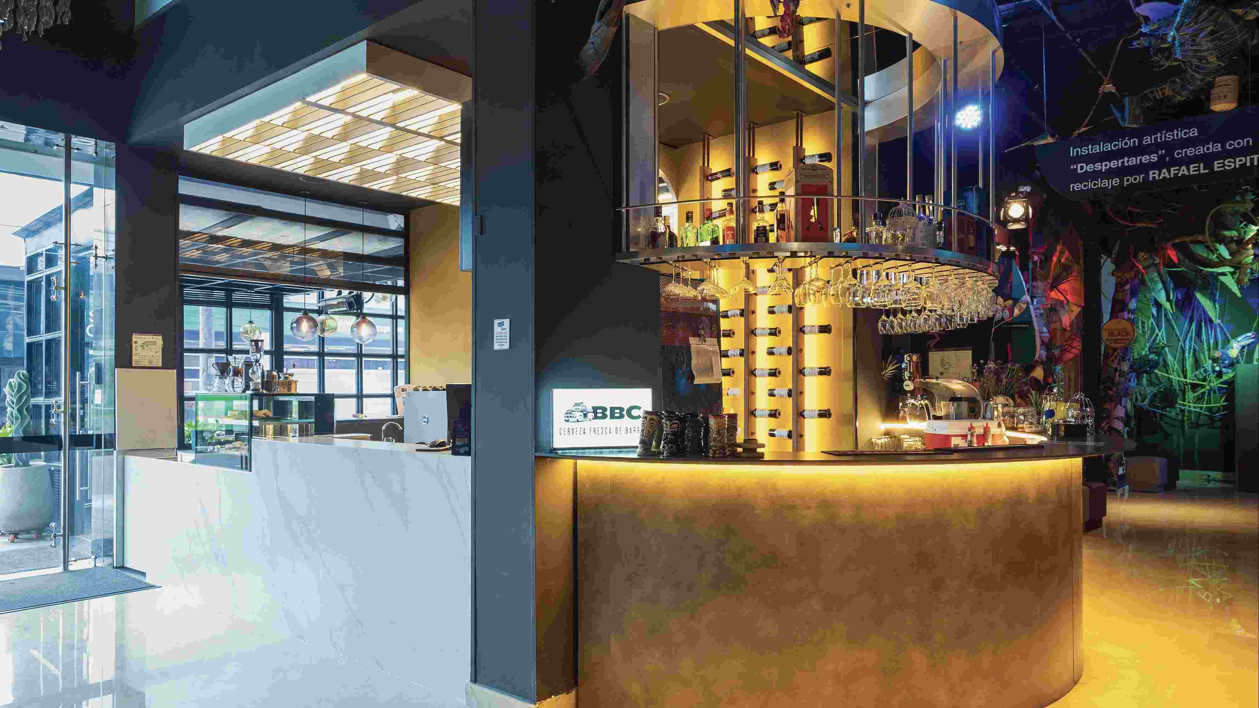 Salón como una recepción con un bar al lado. Se observan varias botellas y copas de cristal.