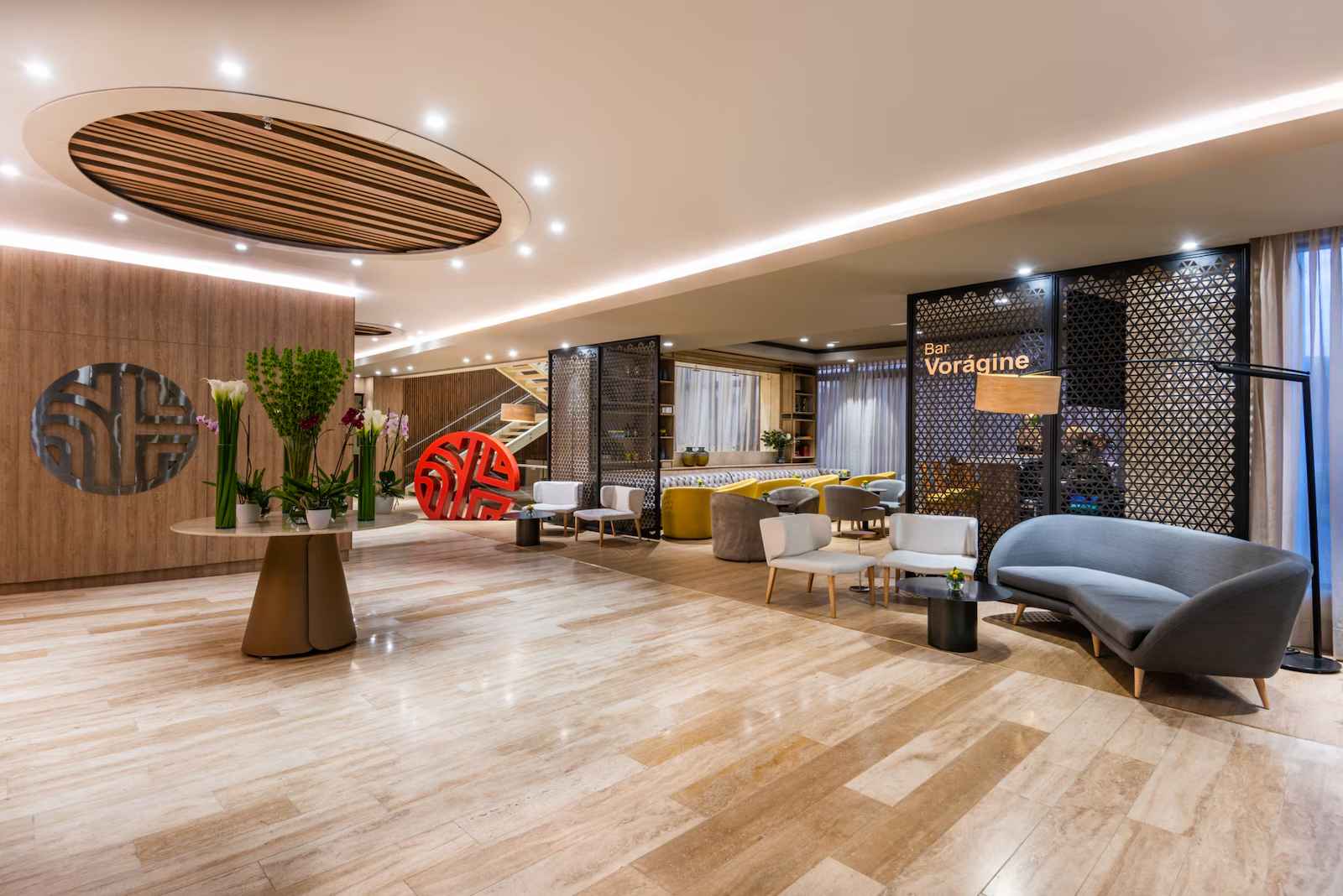  Salón que parece una recepción en donde hay poltronas y sofás.
