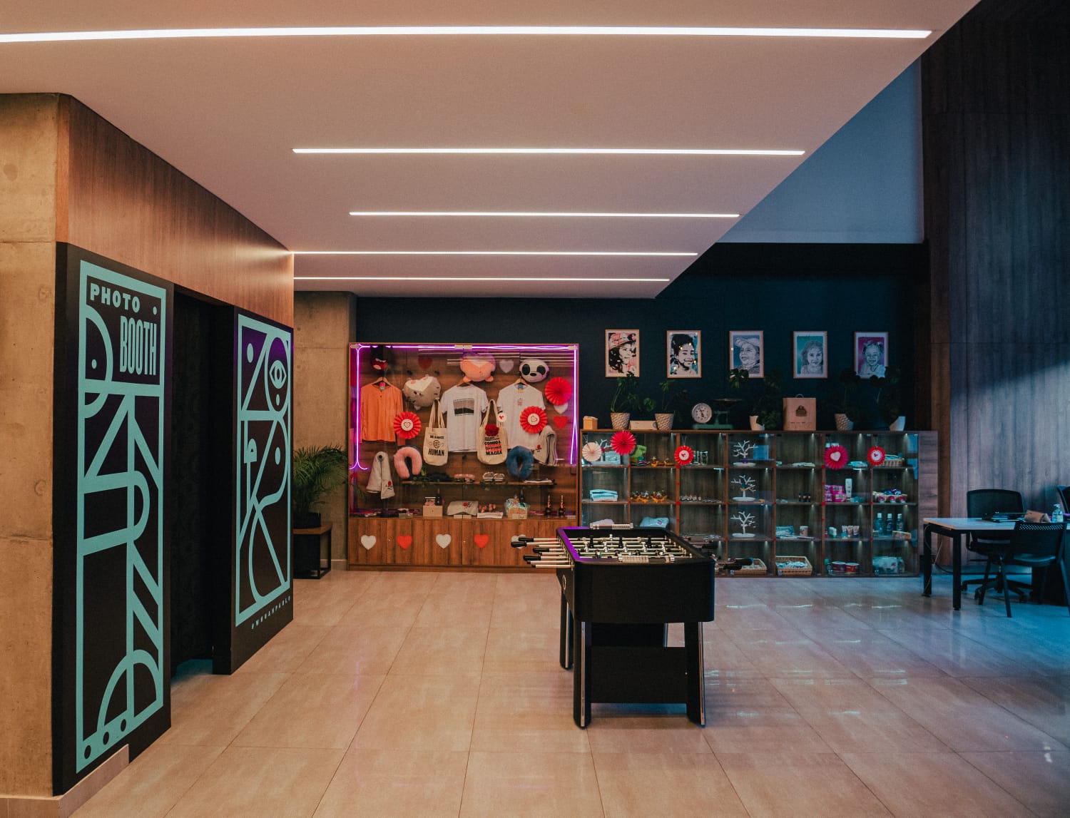 Salón en el que hay varias vitrinas con varios objetos decorativos y camisetas. Hay mesa de futbolín.
