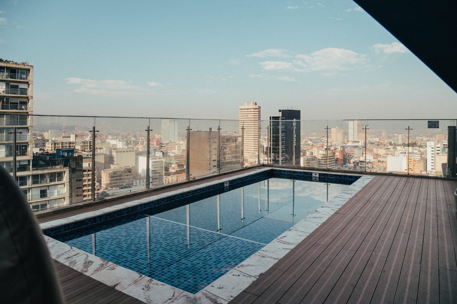  Piscina en terraza de un piso alto, descubierta, y desde la que se observan edificios cerca y lejos.