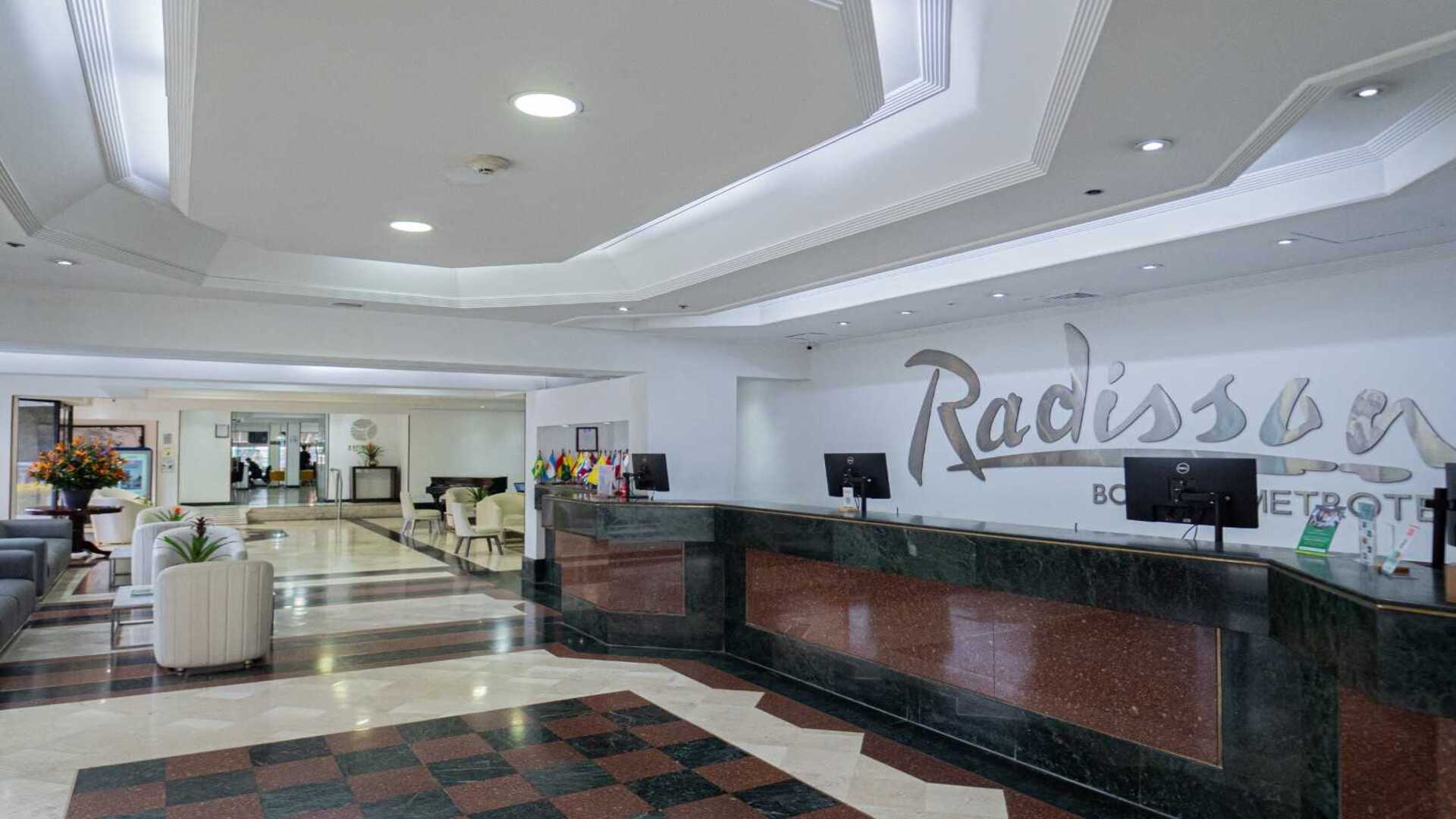  Recepción amplia y elegante de un hotel en Bogotá, con mostrador de atención, iluminación moderna y zonas de espera que reflejan un ambiente cómodo y contemporáneo para los visitantes.