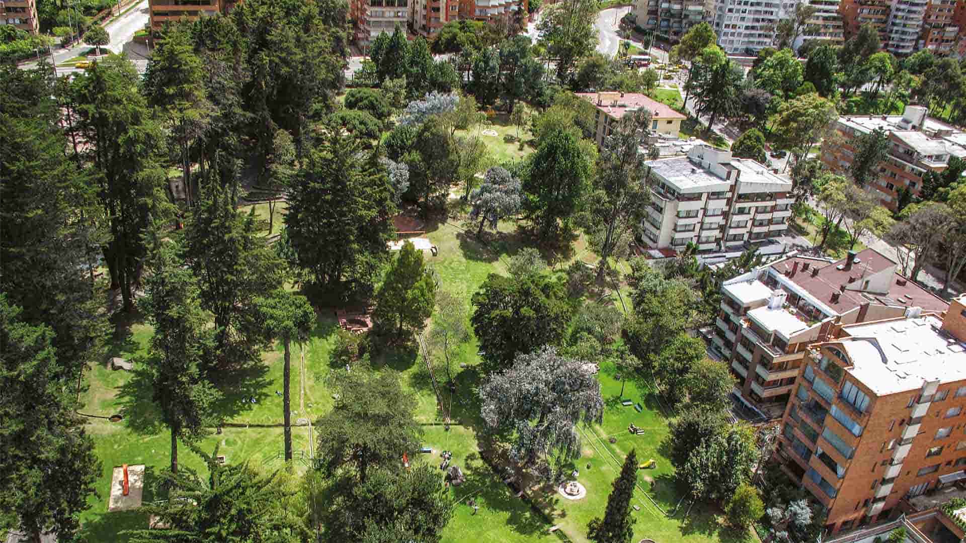 Vista aérea del Parque Museo El Chicó, un amplio espacio verde rodeado de árboles, senderos y jardines, en medio del entorno urbano de Bogotá. Este oasis natural combina patrimonio, naturaleza y tranquilidad en el norte de la ciudad.