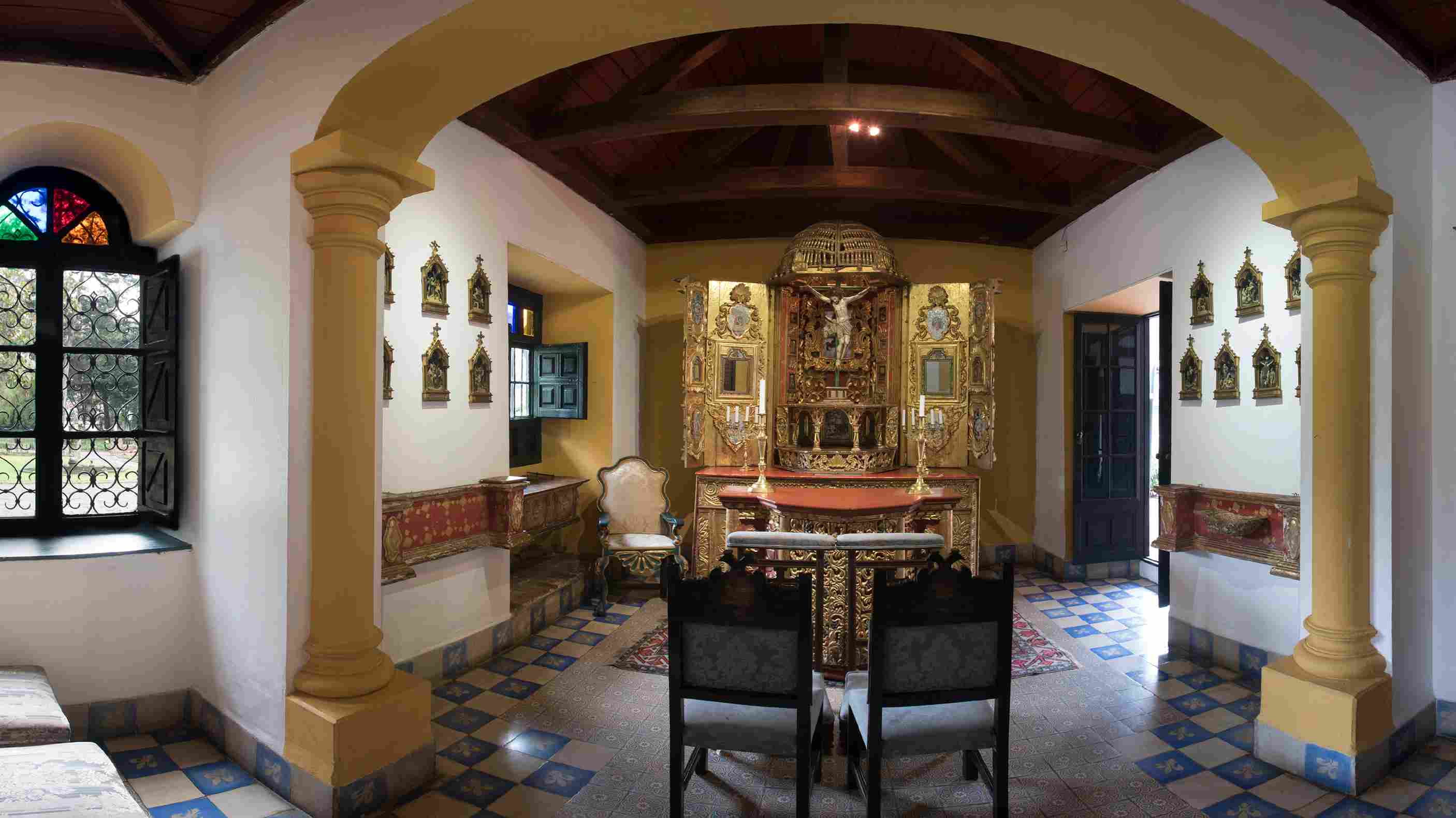 Una capilla de estilo colonial conserva un altar tallado en madera con detalles dorados, rodeado de arcos, vitrales y un techo de vigas de madera. Su ambiente solemne y su riqueza artística evocan el valor histórico y espiritual de este espacio patrimonial.