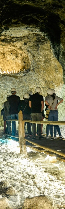 Visitantes recorren una formación rocosa dentro de una cueva, en medio de un destino natural para una escapada.