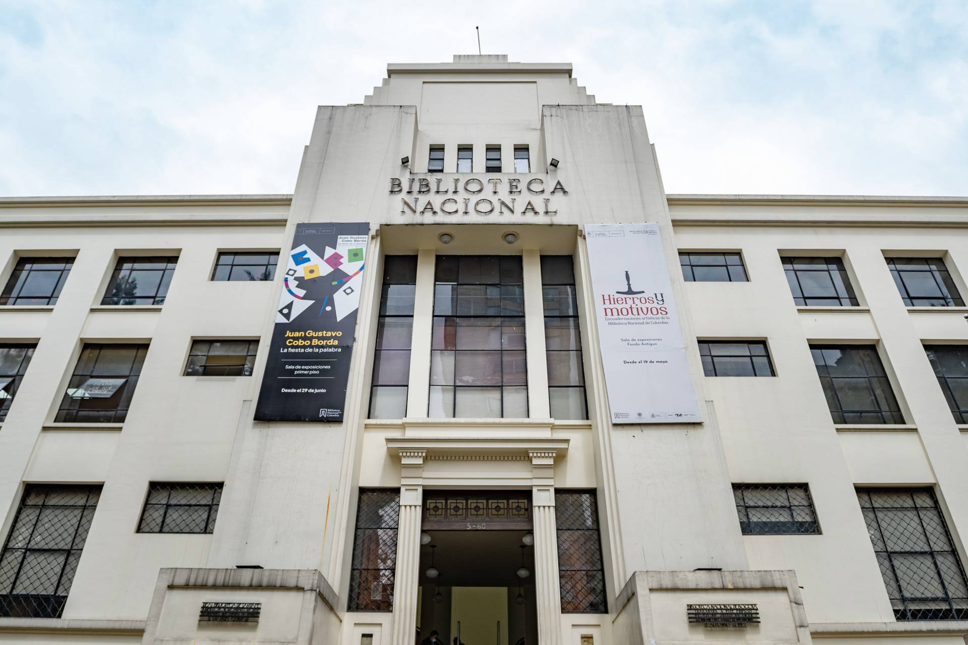 Biblioteca Nacional de día fachada con pañete blanco, ventanas y amplia puerta abierta.