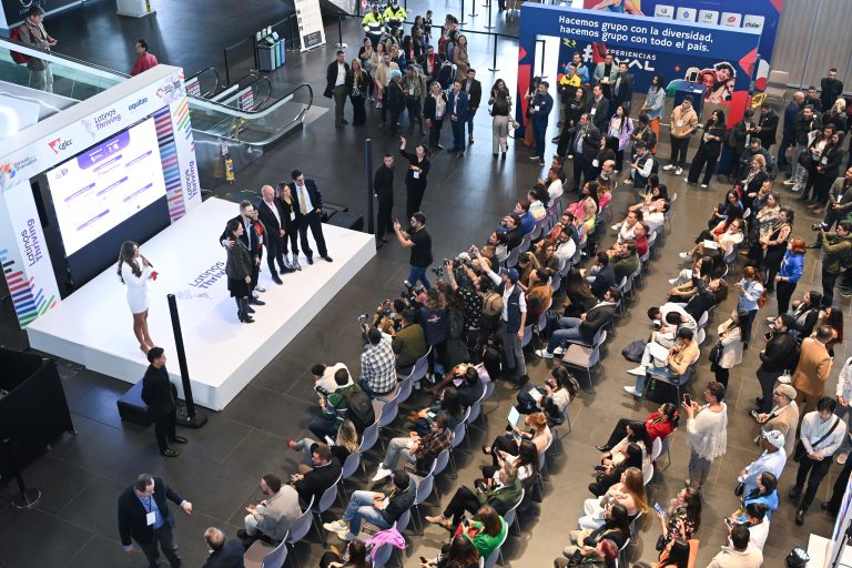 Vista panorámica de un evento empresarial sobre diversidad e inclusión, con decenas de asistentes reunidos frente a un escenario donde se desarrollan presentaciones y paneles, promoviendo el intercambio de conocimientos y buenas prácticas en entornos laborales diversos.