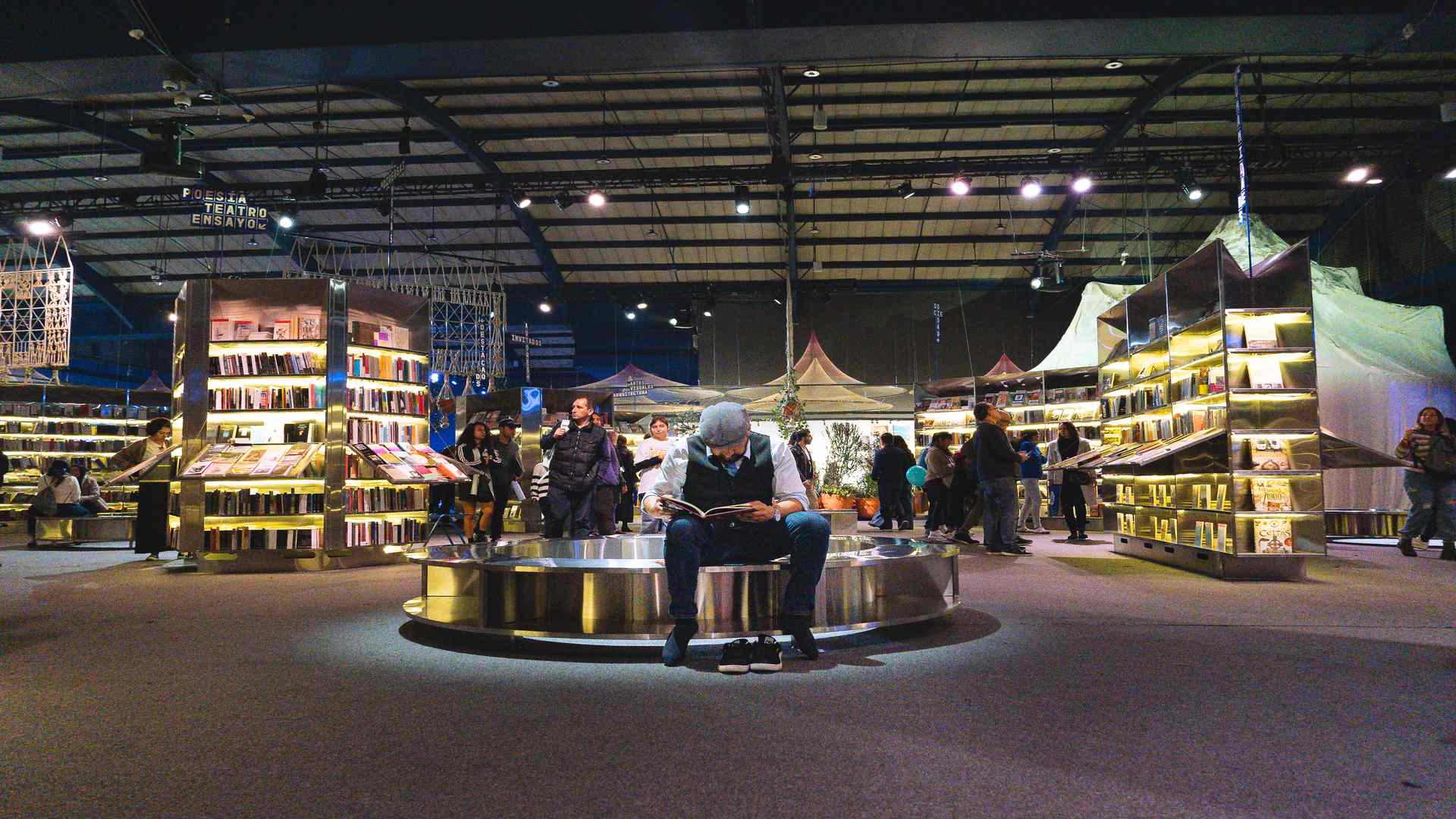 Una asistente se concentra en su lectura en medio de la actividad de uno de los pabellones feriales. Fotografía: Mateo Caballero Archivo IDT.