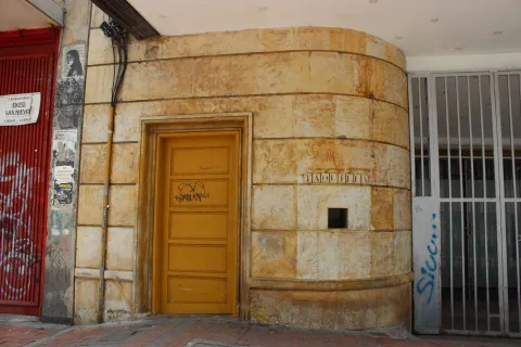 Auditorio Mayor con puerta amarilla en la fachada con algunos grafitis y un letrero que dice taquilla.