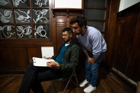 Chucuy Club con un par de hombres jóvenes observan el dibujo que hizo uno de ellos. 