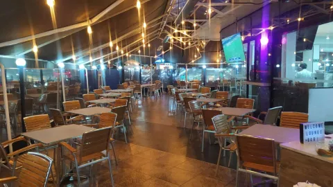Salon con mesas y sillas de madera en un bar.