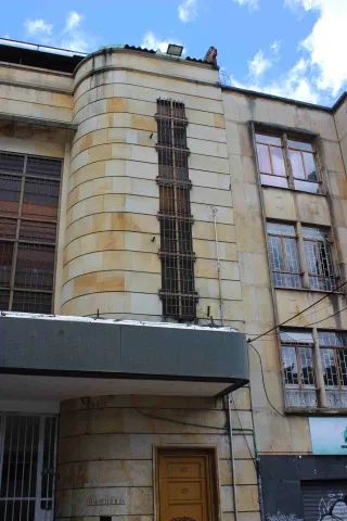  Auditorio Mayor fachada con un segundo piso en placas de piedra amarilla y ventanas cubiertas por rejas negras.
