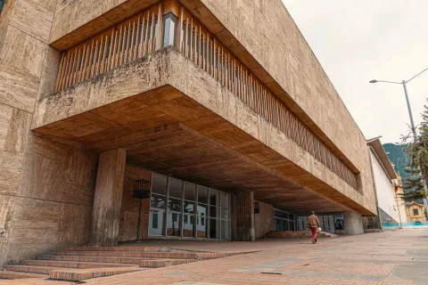 Luis Ángel Arango Library, modern section with a façade of brown tiles. A man is walking in front.