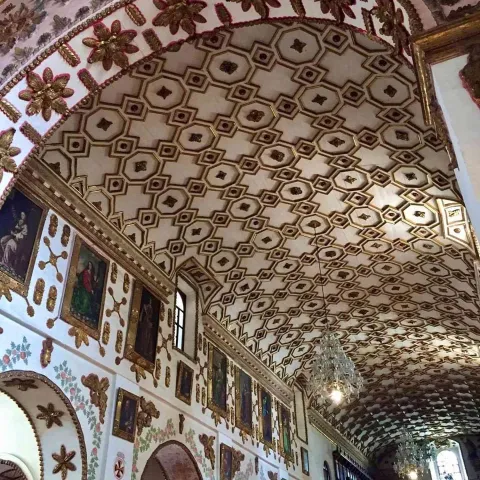 Church of St. Augustine, interior view of the ceiling in Mudéjar style with Islamic and Christian motifs, and walls filled with paintings.