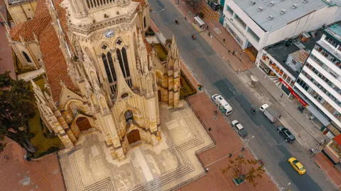 Iglesia Lourdes fachada de la iglesia vista en picada con sus agujas góticas, el techo y el reloj. Alrededor la calle 63 y algunos automóviles parqueados.