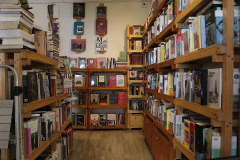 Garabato Libros, hallway lined on both sides and at the far end with wooden bookshelves of four and five levels, filled with books.