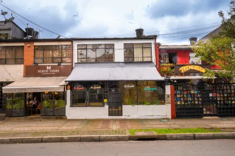 Park Way con fachada de frente tres restaurantes Serge Thiry, Le Tiende y Trementina en casas de dos pisos. Al fondo de uno de ellos se ven personas conversando.