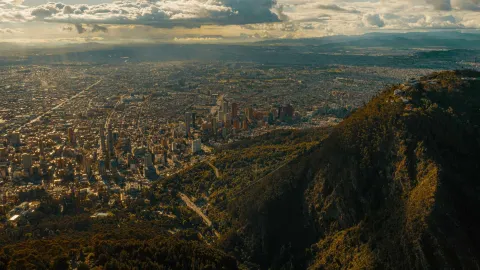 Eastern Hills overlooking the city from the top of a mountain. The sky is blue with clouds and rays of sunlight.