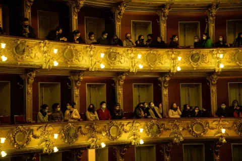 Teatro Colónr with audience members seated in two balconies, some of them wearing face masks.