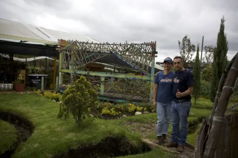 Pareja sonríe al frente de finca productora.
