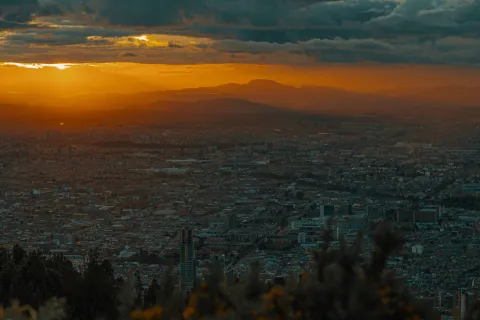 Sunset in Bogotá from a mountain, orange sky and gray clouds.