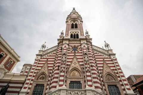 Santuario Nuestra Señora del Carmen primer plano vista desde abajo desde las tres puertas a la punta de la torre gótica. El cielo está gris.