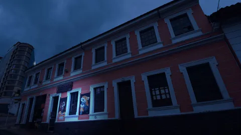 Casa de fachada rosa en La Candelaria con tono azul de anochecer.