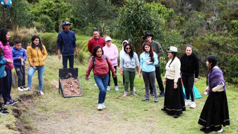 Grupo de personas en el campo jugando tejo. Una mujer adulta está lanzando el disco de tejo.