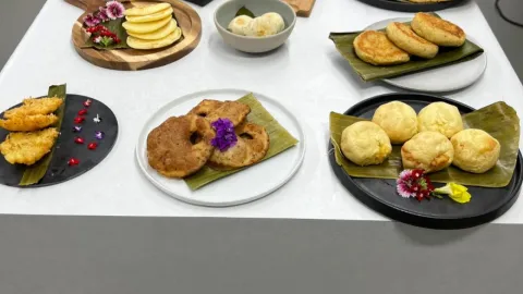 Exhibición de todo tipo de arepas sobre una mesa rectangular con mantel blanco.