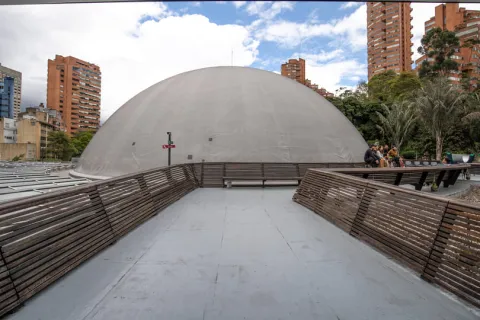 Domo en concreto en una azotea con personas jóvenes sentadas alrededor. Detrás se observan edificio altos.