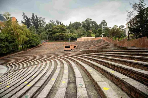 Oval-shaped brick gallery or grandstand surrounded by leafy trees.