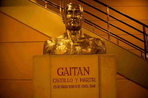 Busto dorado en bronce con la imagen de Jorge Eliecer Gaitán. LLeva tallados el citado nombre, la frase "Caudillo y Martir"  y la fecha de su nacimiento y muerte.