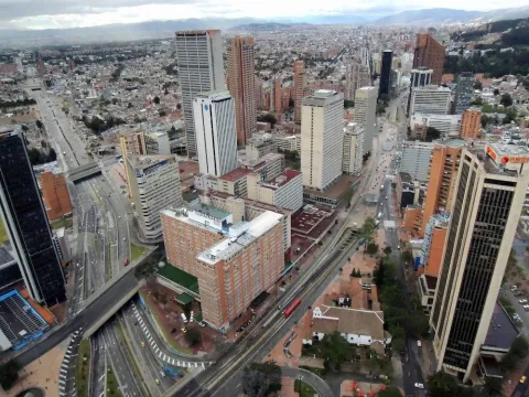 A daytime view from the observation deck looking down, showing Calle 26 and Carrera Séptima with several buildings, including the Hotel Tequendama.