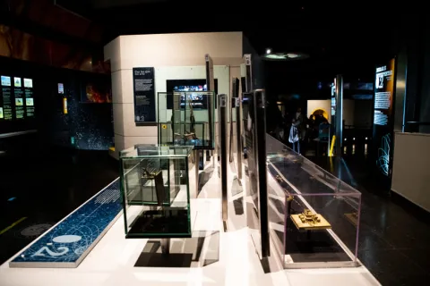 Interior de un museo en el que a oscuras se ven vitrinas. 