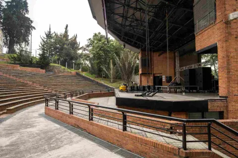 Close-up of the stage with some sound speakers. Trees surround the area.
