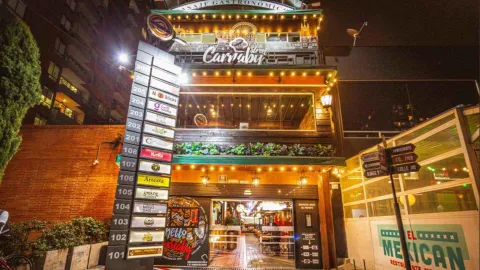 Fachada nocturna iluminada de "Pasaje Gastronómico Carnaby", un vibrante centro de restaurantes.