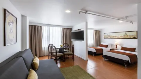  Un dormitorio acogedor y romántico, con una cama con dosel decorada con luces cálidas y adornos en forma de corazón. La iluminación tenue crea un ambiente íntimo.
