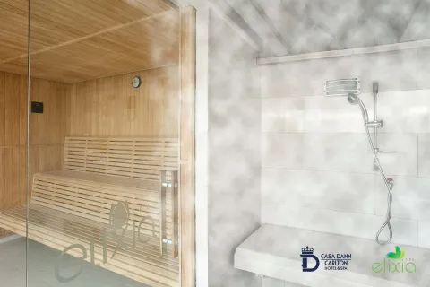 Salón tipo sauna y baño turco dividido por una pared de vidrio. Se observa una capa gruesa de vapor en el lugar.