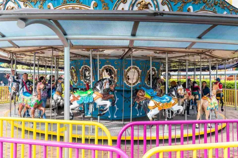 Carrusel, atracción mecánica de caballos en movimiento con algunas personas en él.