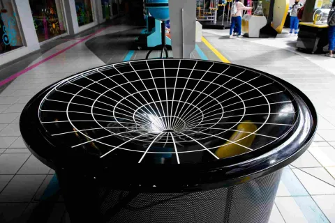 Figura geométrica compuesta por un embudo negro con rayas blancas que simula un hoyo negro.