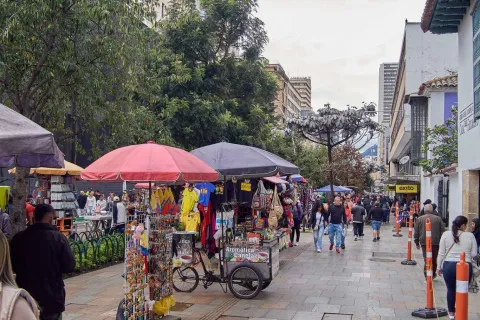 Panoramic view of a street with street vendors and people walking around.