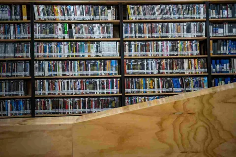 A large bookshelf filled with boxes containing what appear to be DVDs.