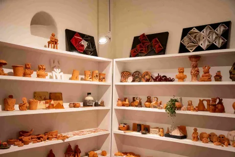  Estantería en madera con una gran colección de objetos de cerámica, de diferentes tamaños y formas. 