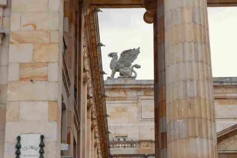 Se observa una figura mitológica alada en el techo de la edificación en piedra.