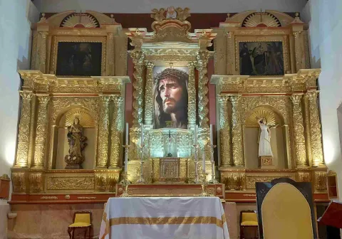 View of the altarpiece, featuring the face of Jesus Christ at the center, framed by beautiful and intricate golden ornamentation.