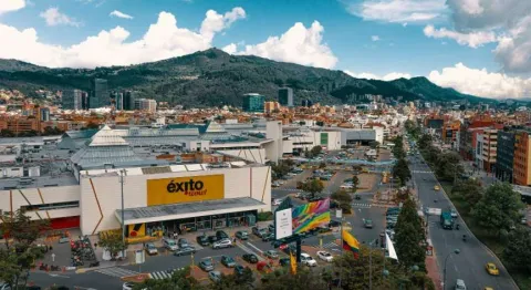  Plano general de la fachada de una gran zona de edificaciones en la que al fondo se ven edificaciones y altas montañas.